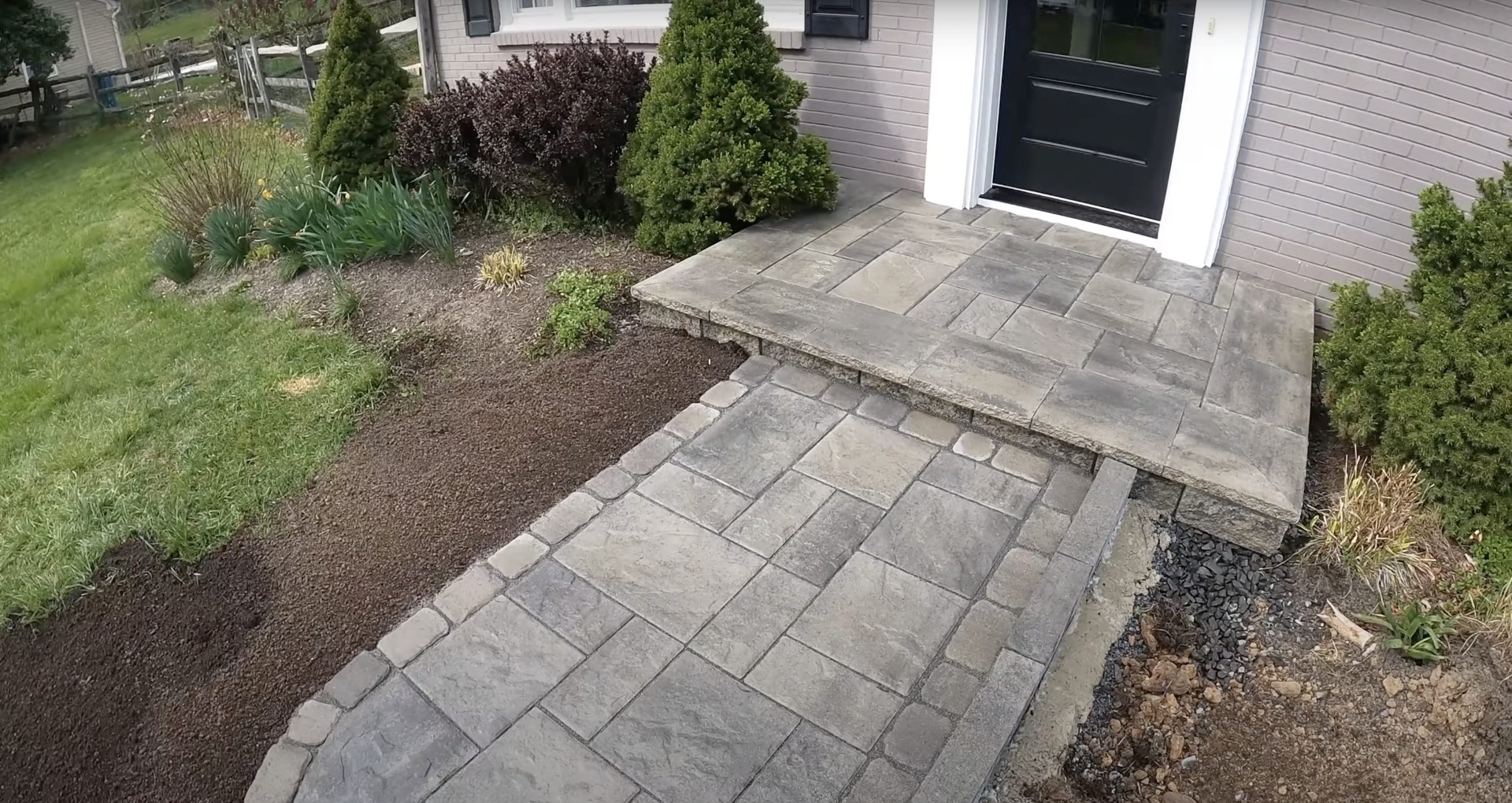 Beautiful stamped concrete patio with natural stone pattern near residential home entrance