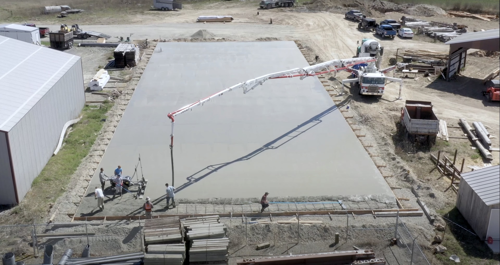 Large-scale commercial concrete slab construction with aerial view of construction site