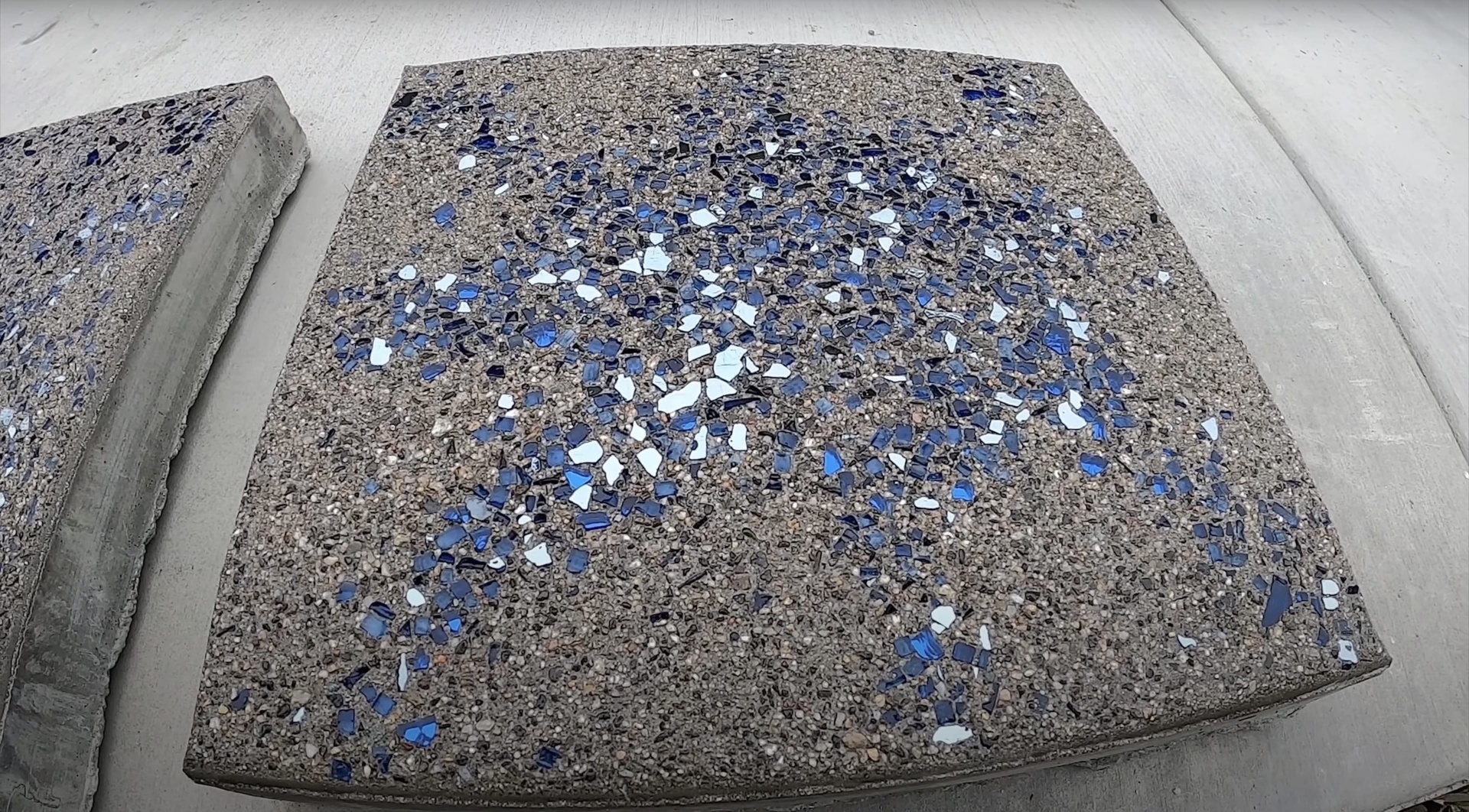 Decorative exposed aggregate concrete sample with blue and white glass accents showcasing design options