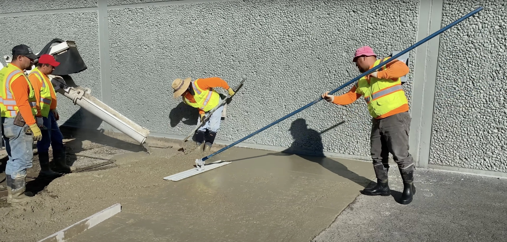 Professional concrete construction team using specialized equipment for commercial project