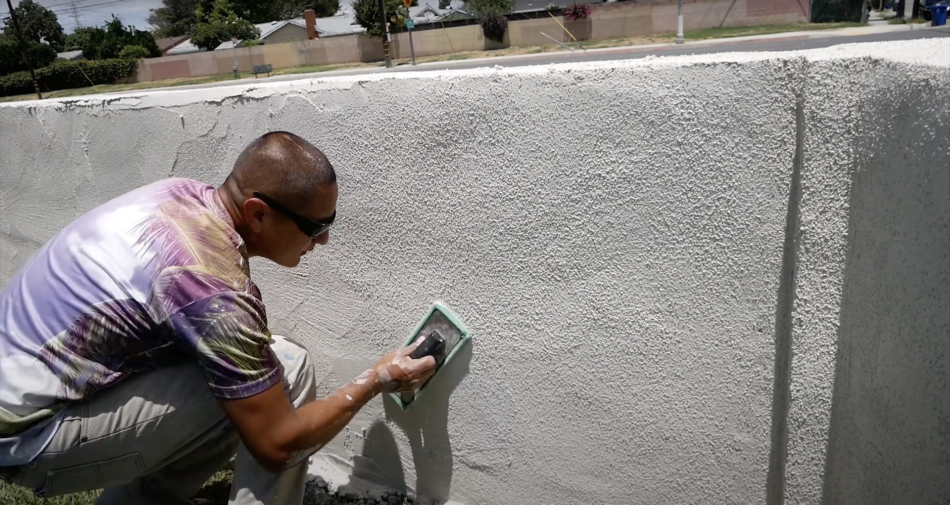 Professional concrete contractor applying specialized textured finish to concrete surface using expert techniques
